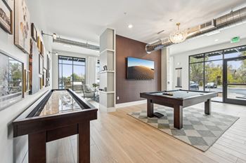 A billiards room with a pool table and a large window